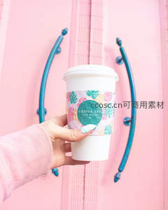 手持热带风咖啡杯对准粉色门