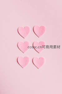 六颗粉色毛毡爱心整齐排列在纯色背景上