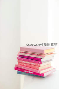 粉色书堆静置于纯白背景前