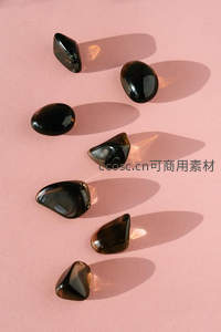 黑色玻璃石块散落在粉红背景上