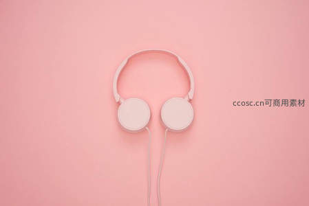 粉色背景上的极简风格耳机特写