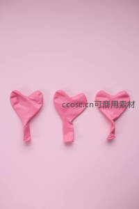 三个粉色心形气球在纯色背景排列