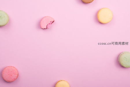 彩色马卡龙散落粉色背景之上