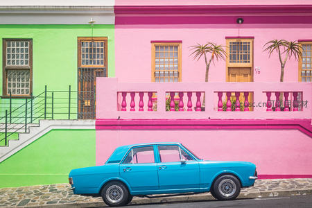 彩色建筑前的复古蓝车