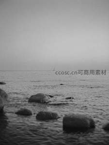 远海帆影与岸边礁石的静谧画面