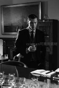 西装绅士手持酒杯沉思