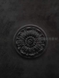 圆形浮雕玫瑰花饰在深色墙面上的特写