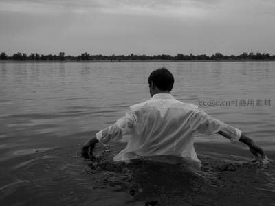黑白影像中男子水中背影沉思
