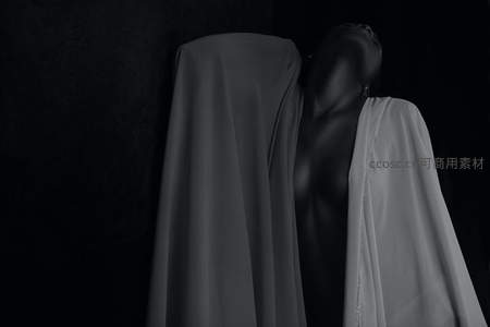暗影中的神秘人形雕塑与垂落布幔