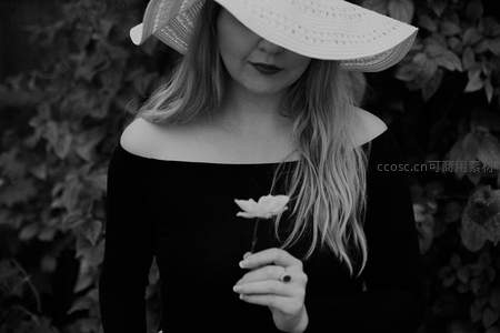 戴帽女子手持白花，优雅静谧肖像