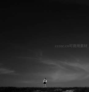 孤独身影伫立旷野苍穹下