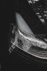 雨滴覆盖的汽车前灯特写细节