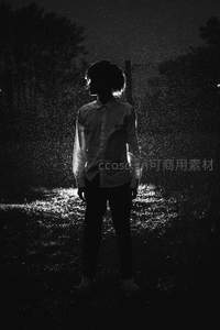 雨夜中逆光站立的青年