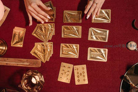 神秘占卜师正在红色桌布上摆塔罗牌