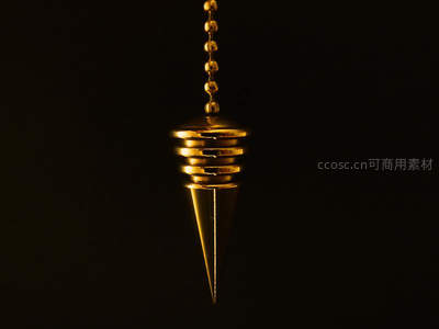 黑暗中悬挂的金色锥形灵摆特写