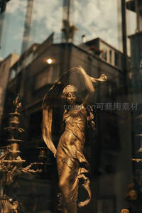 金色舞者雕像映衬城市街景