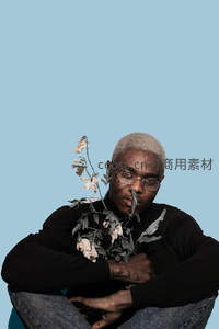 男子怀抱枯花凝视镜头