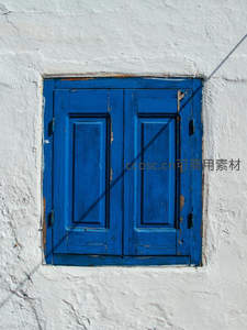 白色墙壁上斑驳的蓝色木窗