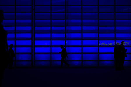 蓝色幕墙前的人影剪影