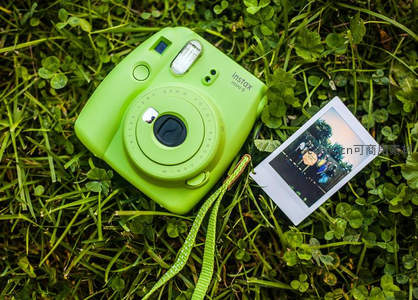 青柠绿拍立得相机躺在青草地上