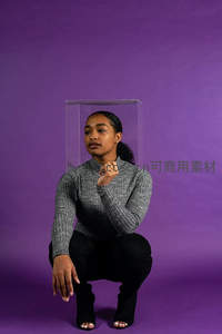 紫幕前女子半蹲凝视透明盒