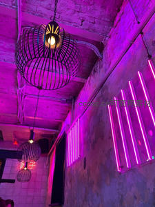 霓虹紫光下的工业风吊灯与砖墙
