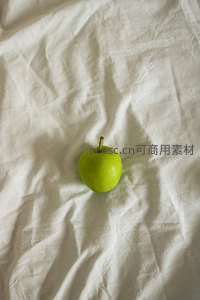 青苹果置于褶皱白布