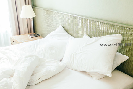 温馨卧室床铺特写，白色床品与藤编床头