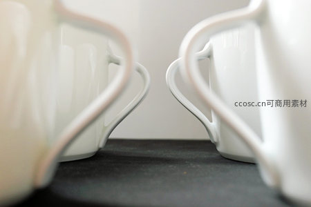 两个白色陶瓷杯柄的对称构图