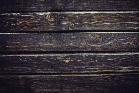 深色木板纹理特写，展现自然年轮与质感