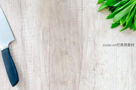 厨房木桌一角，刀与绿叶静物