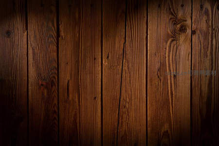 暖光照射下的深色木墙，光影斑驳显质感