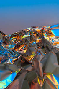 褶皱金属箔在渐变天空下的炫彩反射