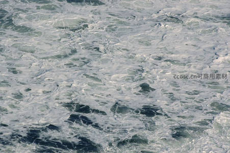 汹涌海浪翻滚，白色泡沫如雪铺满深蓝海面