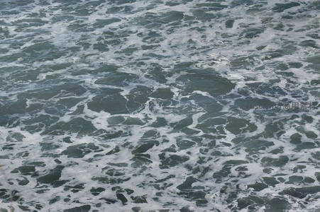 深绿海面波涛汹涌，洁白浪花交织成动感纹理