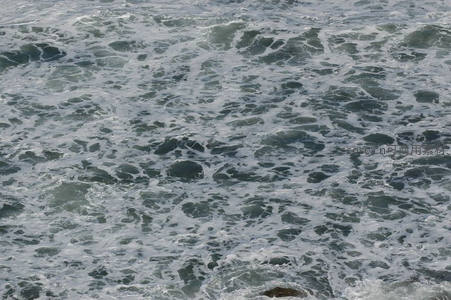 近岸浪花飞溅，海水与岩石激烈碰撞