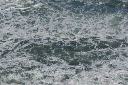 深蓝海浪翻腾，泡沫如雪覆盖洋面