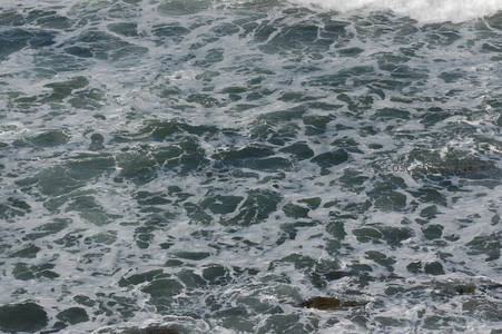 汹涌海浪拍打礁石，白色泡沫翻腾不息