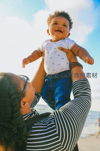 海边高举宝贝，阳光下的欢笑