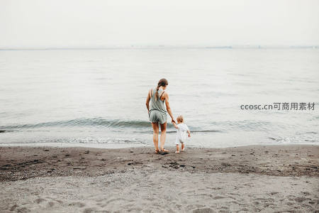 母女牵手漫步沙滩，背影诉说温柔