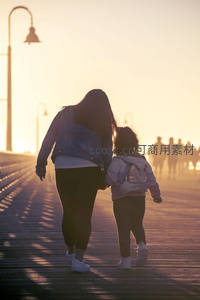 夕阳下母女牵手漫步，背影诉说陪伴美好
