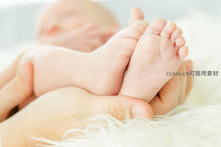 新生婴儿小脚丫被温柔托在掌心