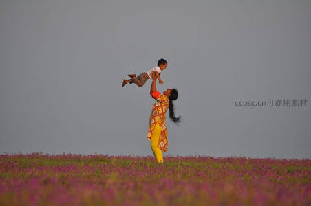 花海中母亲高举孩子欢笑