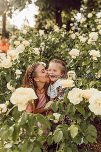 玫瑰花丛中母女温馨亲吻瞬间