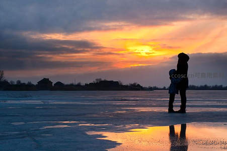 冰面夕阳下母子相拥剪影