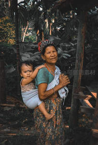 热带雨林中祖孙相依，传统服饰显温情