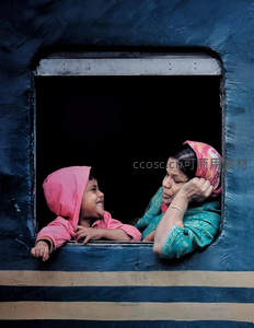 火车窗边母子对望，旅途中的温暖笑容