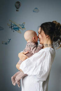 母亲怀抱婴儿亲吻，温馨亲子时刻
