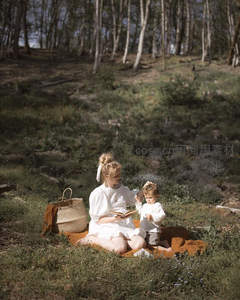 森林野餐母子阅读，阳光透过树影洒满草地
