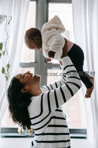 母亲高举婴儿，共享幸福时光